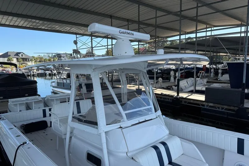 Slide: The Image of 2005 Intrepid 370 Center Console boat docked in a marina under a covered structure. - 14