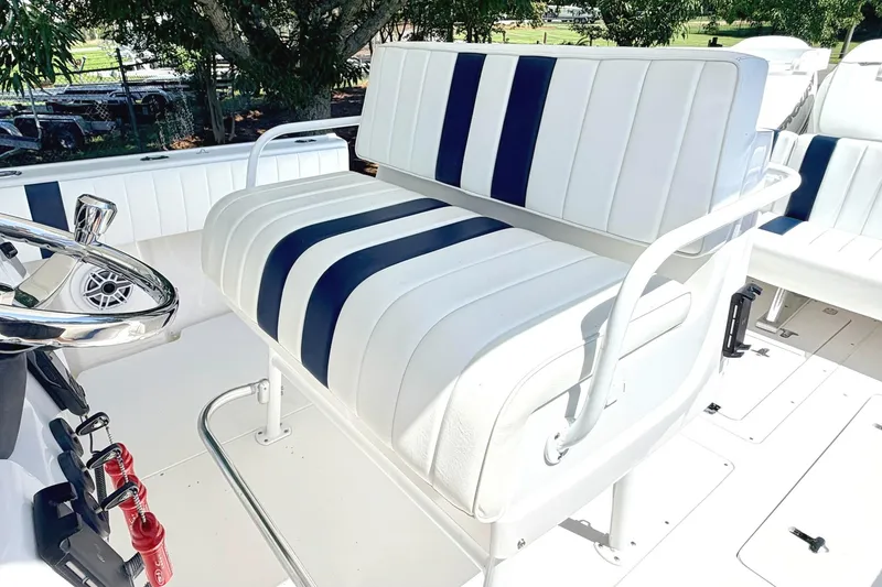 Slide: The Image of 2005 Intrepid 370 Center Console boat with striped seating and steering wheel. - 22