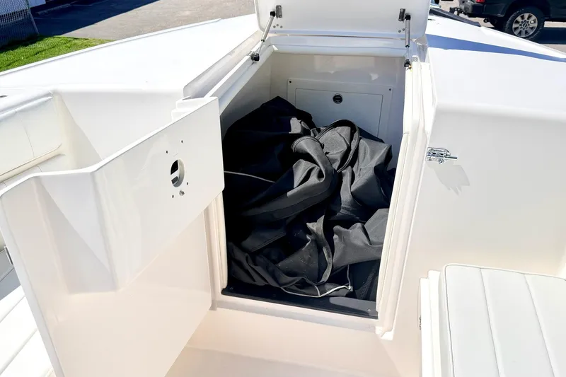 Slide: The Image of Storage compartment on a 2005 Intrepid 370 Center Console boat, open with black cover inside. - 35