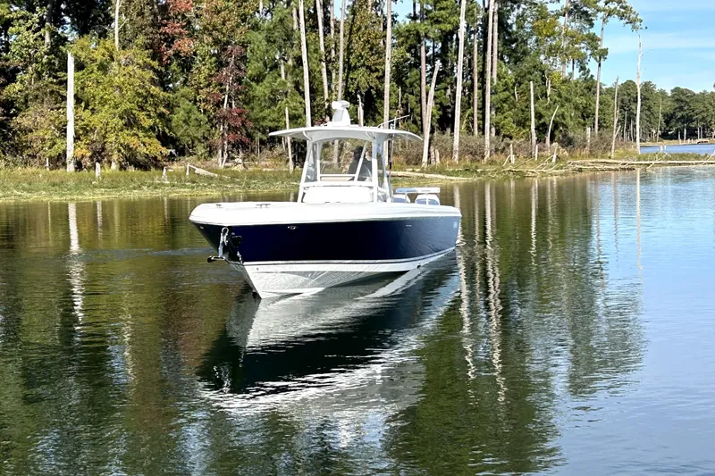 Slide: The Image of 2005 Intrepid 370 Center Console boat on calm water, surrounded by trees. - 4
