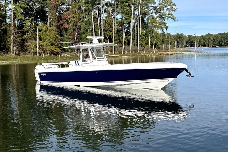 Slide: The Image of 2005 Intrepid 370 Center Console boat on calm lake with forested shoreline. - 8