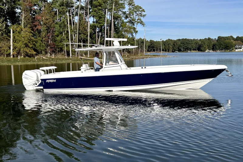 Slide: The Image of 2005 Intrepid 370 Center Console boat cruising on a calm lake with trees in the background. - 9