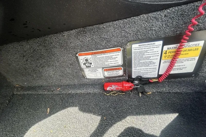 Slide: The Image of 2022 Tracker Pro Team 175 TF boat interior with safety labels and keys. - 12