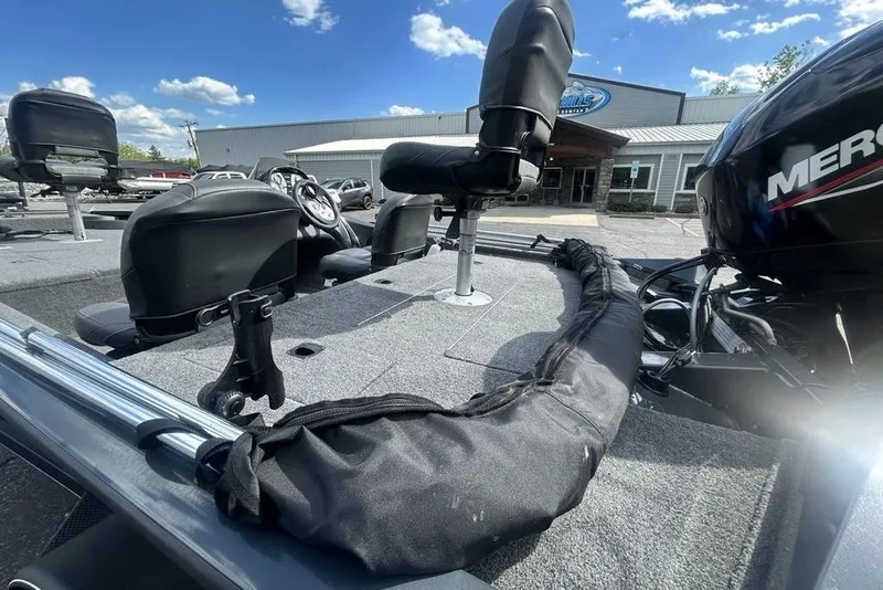 Slide: The Image of 2022 Tracker Pro Team 175 TF boat interior with seats and Mercury engine, under a clear sky. - 5