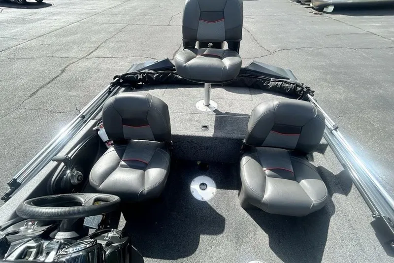 Slide: The Image of 2022 Tracker Pro Team 175 TF boat interior with three gray seats on a sunny day. - 6