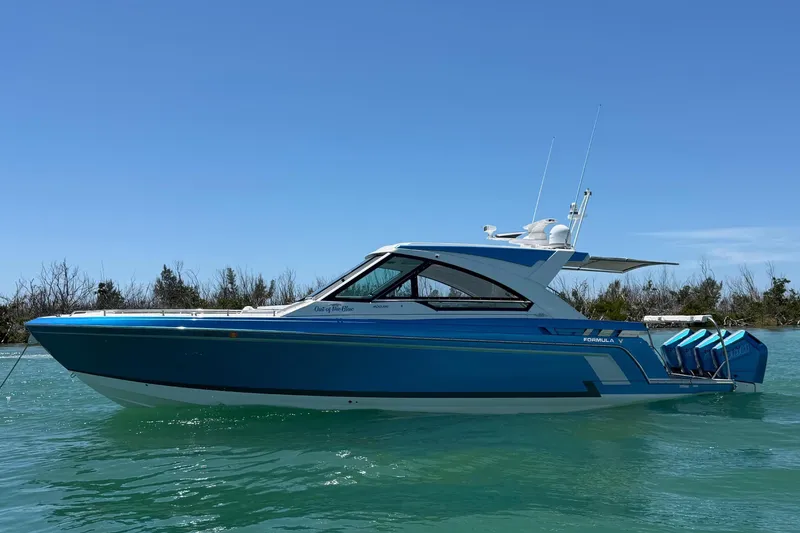 Slide: The Image of 2024 Formula 400 Super Sport Crossover boat on turquoise water under clear blue sky. - 2