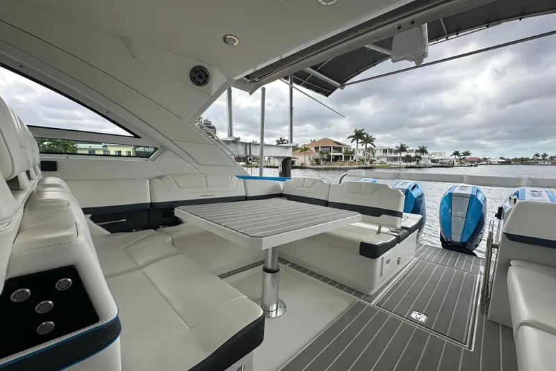 Slide: The Image of 2024 Formula 400 Super Sport Crossover yacht interior with seating and table, overlooking waterfront homes. - 24