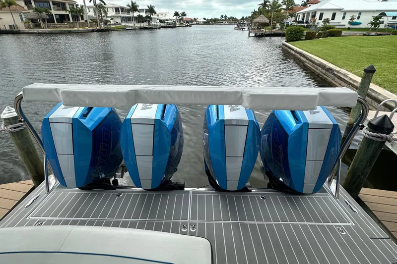 Slide: The Image of Four blue outboard motors on a 2024 Formula 400 Super Sport Crossover boat docked by a canal. - 5
