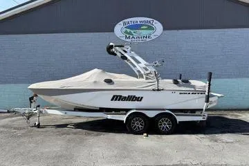 The Image of 2020 Malibu Wakesetter 21 VLX boat with cover, parked on a trailer outside Water Werks Marine. - 1