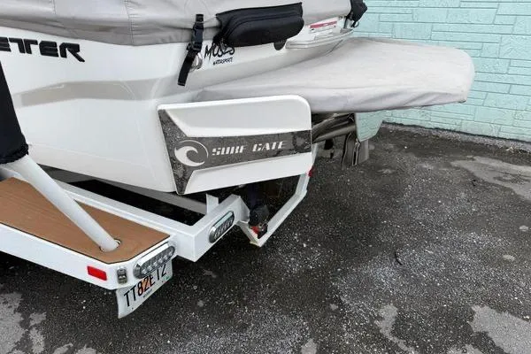 Slide: The Image of 2020 Malibu Wakesetter 21 VLX boat with Surf Gate feature, parked on pavement. - 16