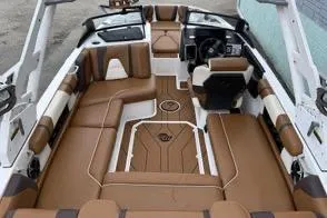Slide: The Image of 2020 Malibu Wakesetter 21 VLX interior with brown and white seating, modern dashboard. - 5