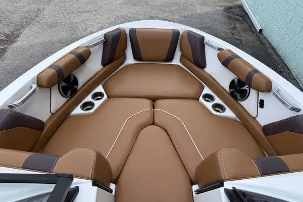 Slide: The Image of 2020 Malibu Wakesetter 21 VLX boat interior with tan leather seating and cup holders. - 6