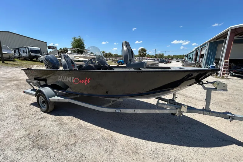 The Image of 2023 Alumacraft Escape 165 SC boat on trailer under clear blue sky. - 1