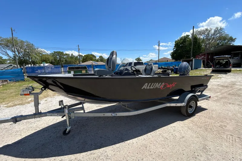 Slide: The Image of 2023 Alumacraft Escape 165 SC boat on trailer under clear blue sky. - 12