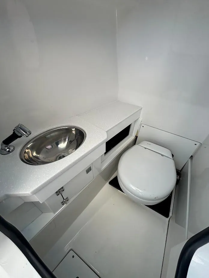 Slide: The Image of Interior of 2021 Blackfin 272 DC featuring toilet and sink. - 16