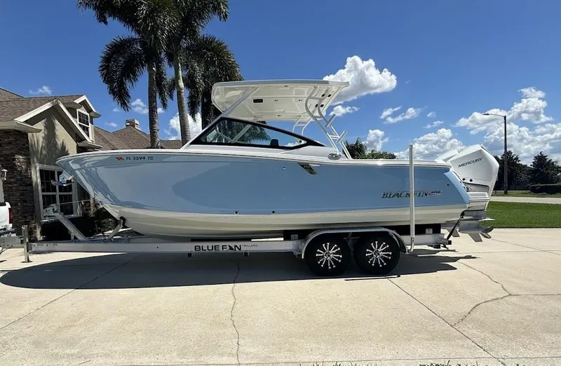 Slide: The Image of 2021 Blackfin 272 DC boat on trailer, sunny day, palm trees in background. - 2