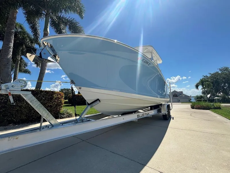 Slide: The Image of 2021 Blackfin 272 DC boat on trailer under palm trees. - 4