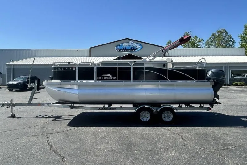 The Image of 2021 Bennington 20 SFX pontoon boat on trailer, parked outside dealership. - 1