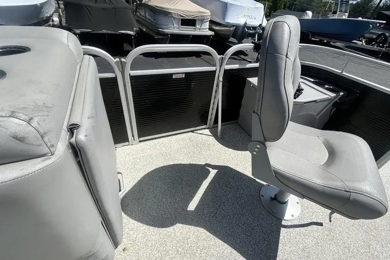 Slide: The Image of 2021 Bennington 20 SFX boat interior with gray seating and deck, docked among other boats. - 15