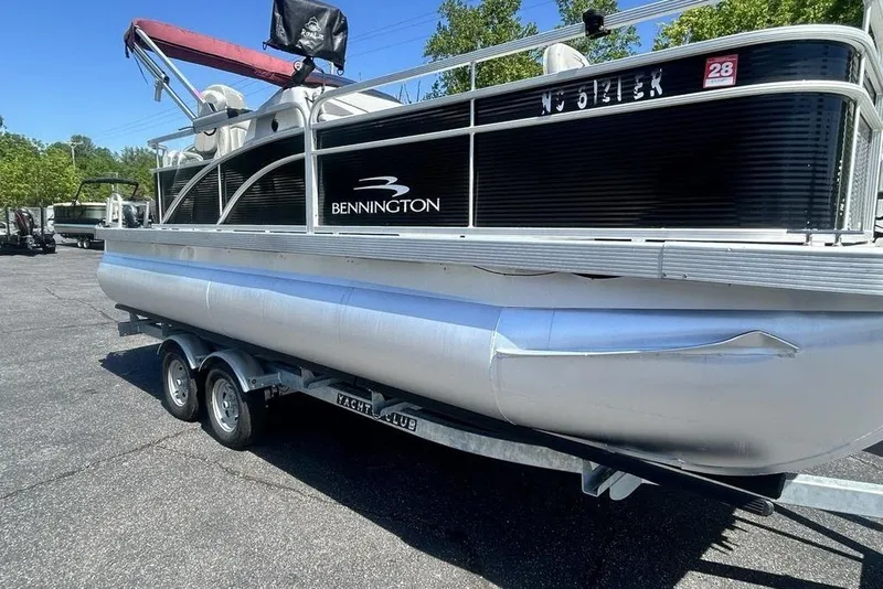 Slide: The Image of 2021 Bennington 20 SFX pontoon boat on trailer, parked outdoors. - 20