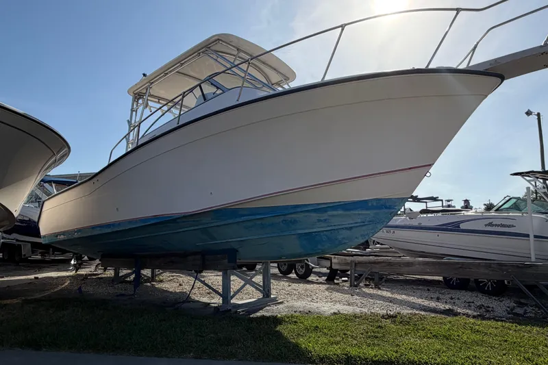 Slide: The Image of 1996 Grady-White Marlin 300 boat on display, elevated on stands, under clear sky. - 5