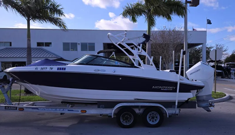The Image of 2023 Monterey M225 boat on trailer, parked near palm trees and building. - 0