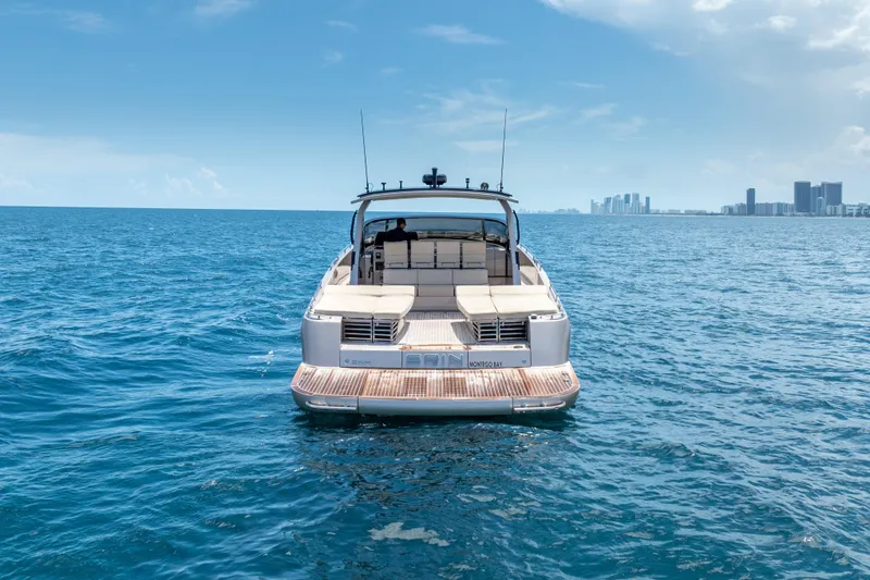 Slide: The Image of Luxury CNM Continental 54 yacht cruising on open sea, city skyline in background. - 12