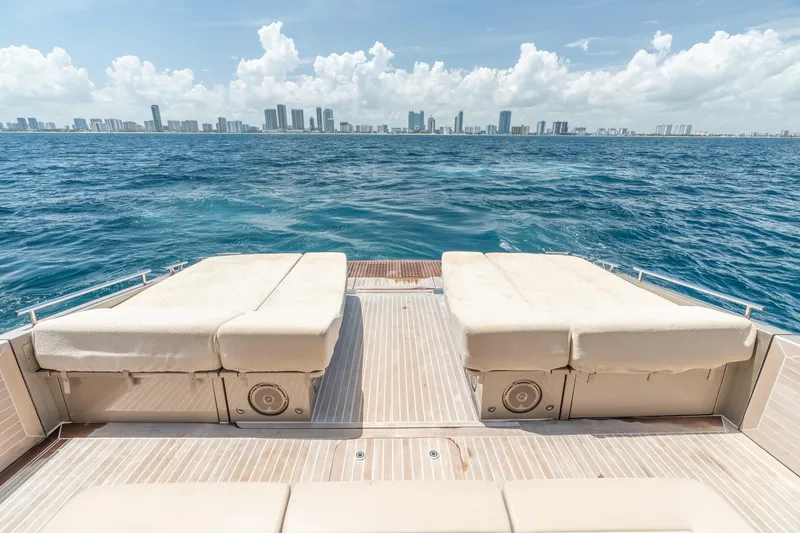 Slide: The Image of Luxury yacht CNM Continental 54, 2019 model, with sunbeds overlooking ocean and city skyline. - 15