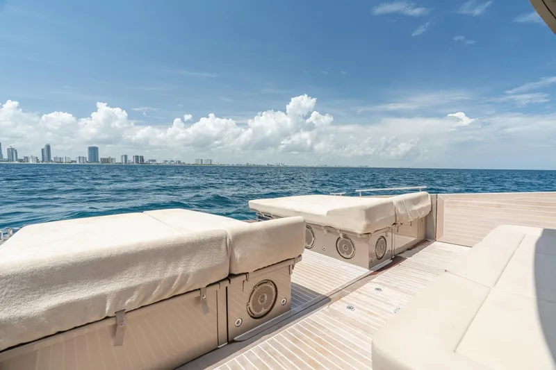 Slide: The Image of Luxurious 2019 CNM Continental 54 yacht with sunbeds, ocean view, and city skyline. - 16