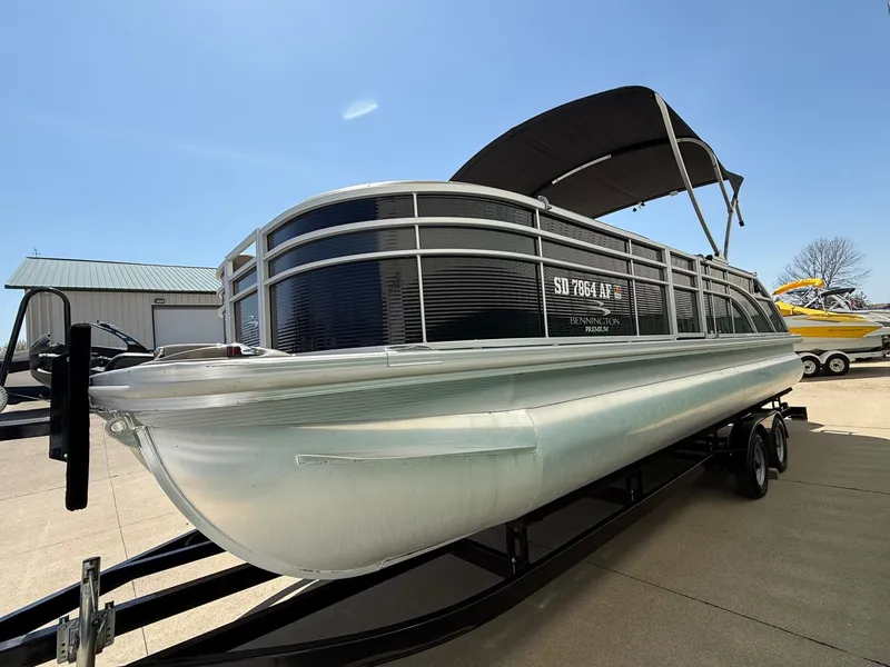 Slide: The Image of 2018 Bennington 25 SX pontoon boat on trailer outdoors. - 2