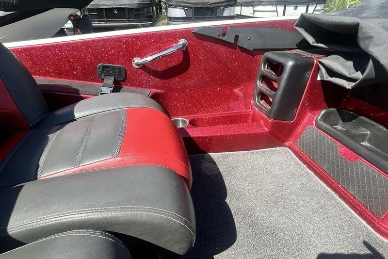 Slide: The Image of 2014 Triton 19XS boat interior with red and gray seating, carpeted floor, and storage compartments. - 13