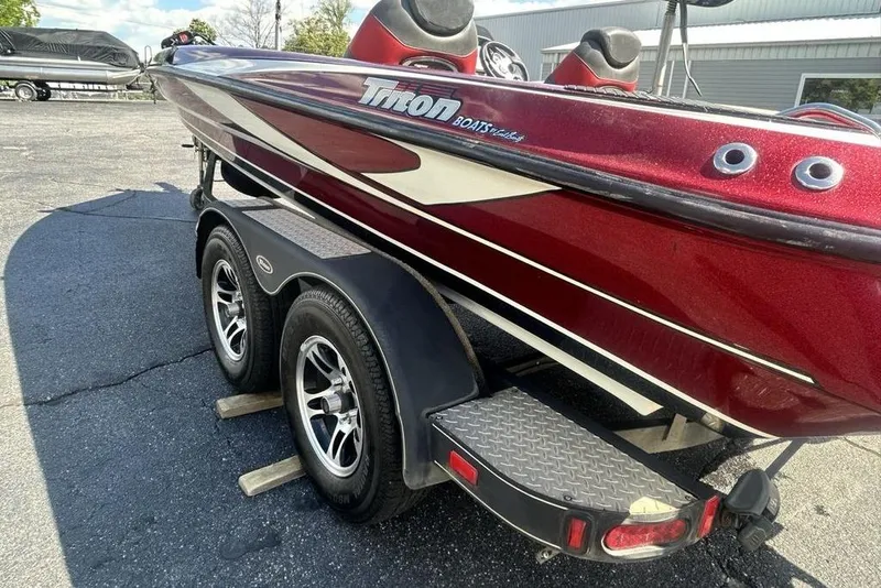 Slide: The Image of 2014 Triton 19XS boat on trailer, red and white design, parked outdoors. - 4