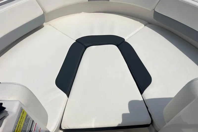 Slide: The Image of 2022 Robalo R227 Dual Console boat with white cushioned seating area. - 10