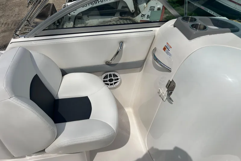 Slide: The Image of 2022 Robalo R227 Dual Console boat interior with white seating and cup holders. - 11