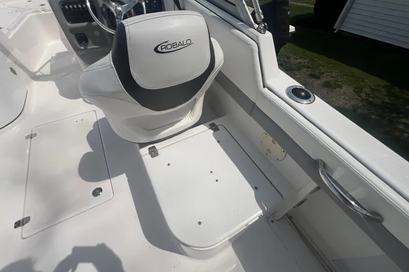 Slide: The Image of 2022 Robalo R227 Dual Console boat interior with steering wheel and seating. - 13