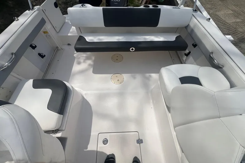 Slide: The Image of 2022 Robalo R227 Dual Console boat interior with white seating and storage compartments. - 14