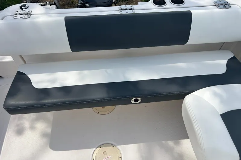 Slide: The Image of 2022 Robalo R227 Dual Console boat seating with white and gray upholstery. - 16