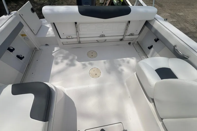 Slide: The Image of 2022 Robalo R227 Dual Console boat interior with white seating and storage compartments. - 18