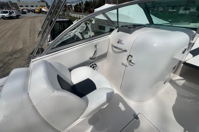 Slide: The Image of 2022 Robalo R227 Dual Console boat interior with white seating and control panel. - 27
