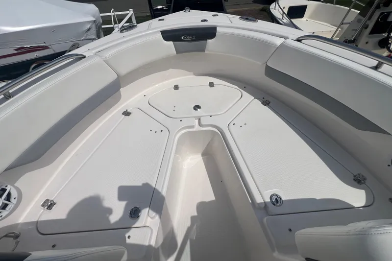 Slide: The Image of 2022 Robalo R227 Dual Console boat interior with white seating and storage compartments. - 29