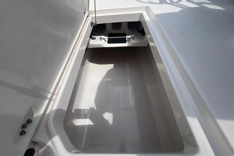 Slide: The Image of Storage compartment of 2022 Robalo R227 Dual Console boat, open and empty. - 35