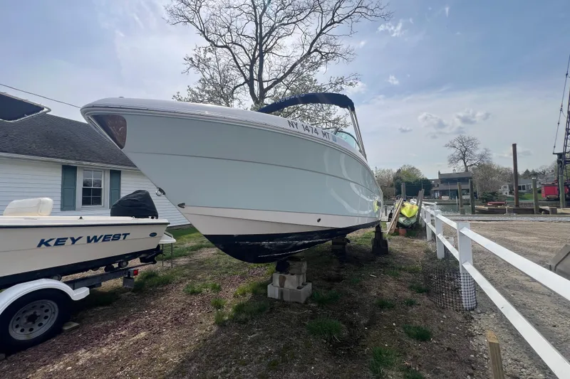 Slide: The Image of 2022 Robalo R227 Dual Console boat on dry dock beside a Key West boat. - 55