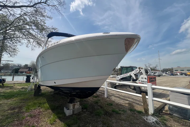 Slide: The Image of 2022 Robalo R227 Dual Console boat on land, under a clear sky. - 56