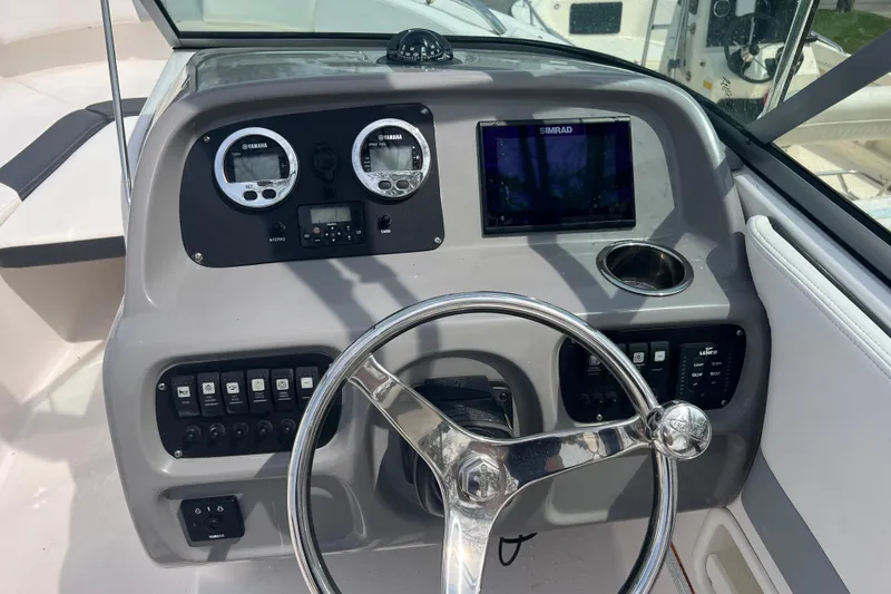 Slide: The Image of 2022 Robalo R227 Dual Console helm with gauges, controls, and steering wheel. - 6