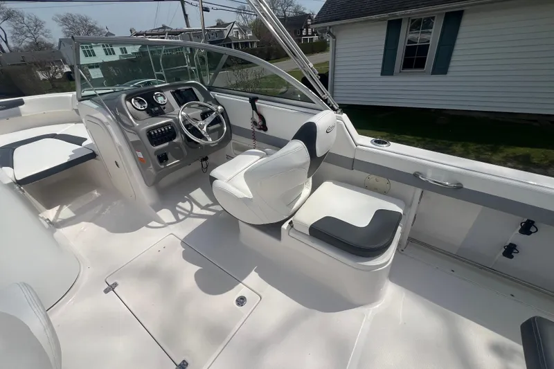 Slide: The Image of 2022 Robalo R227 Dual Console boat interior with steering wheel and seating. - 8