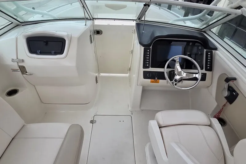Slide: The Image of 2017 Robalo R247 Dual Console boat interior with steering wheel and seating. - 12