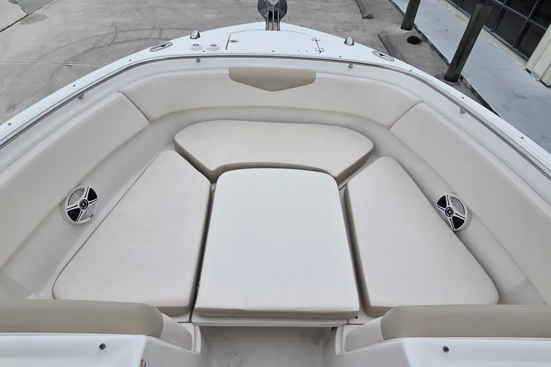 Slide: The Image of 2017 Robalo R247 Dual Console boat interior with cushioned seating and speakers. - 18