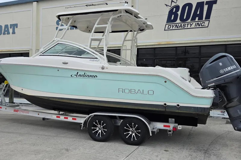 Slide: The Image of 2017 Robalo R247 Dual Console boat on trailer at dealership, featuring Yamaha outboard motor. - 2