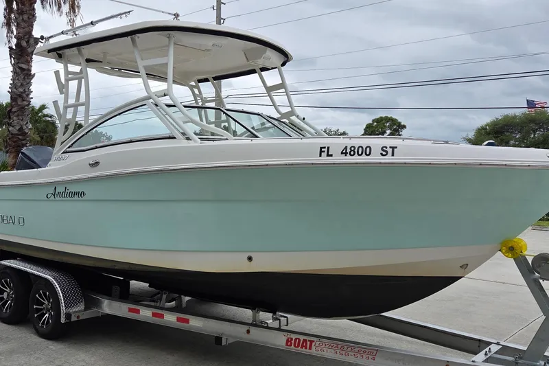 Slide: The Image of 2017 Robalo R247 Dual Console boat on trailer, light blue hull, parked outdoors. - 4