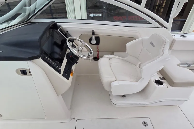 Slide: The Image of 2017 Robalo R247 Dual Console boat interior with steering wheel and captain's seat. - 8